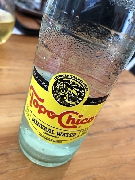 A cold glass bottle of Topo Chico mineral water