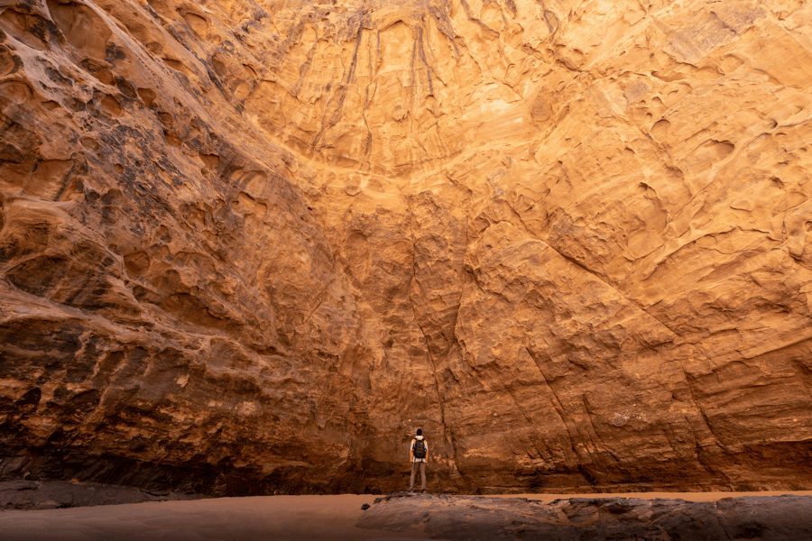 A man confronting a giant stone wall