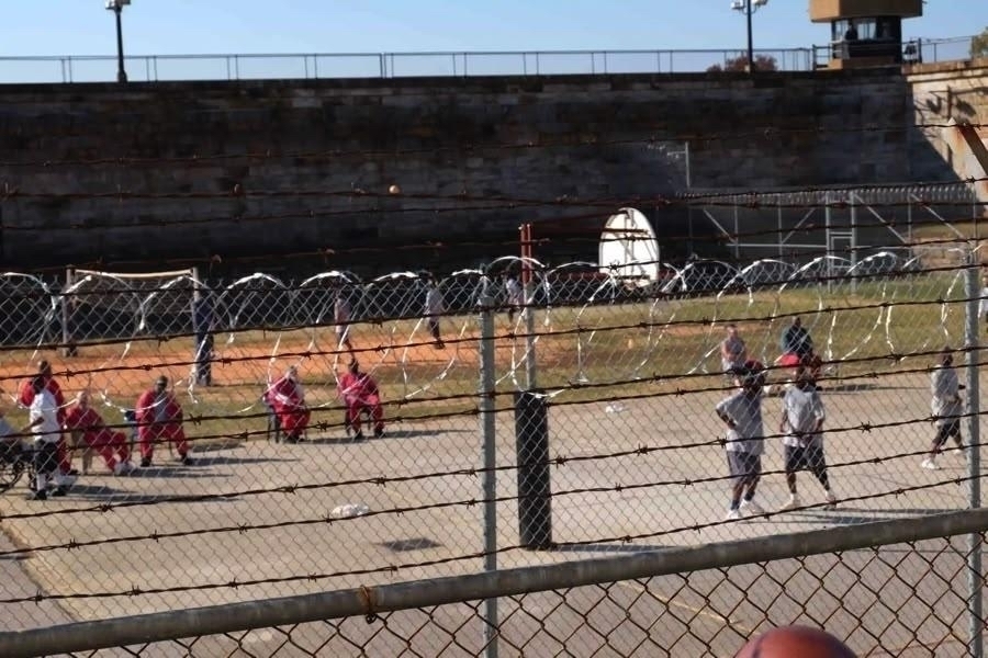 Prison inmates playing basketball on the yard