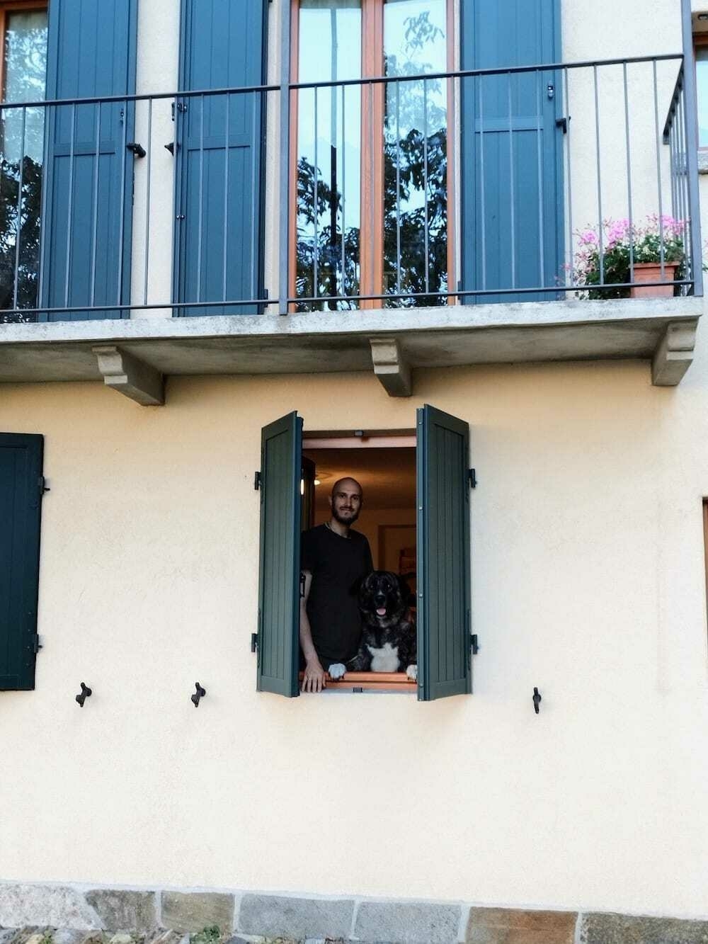 a man looking out the open window of an Italian building