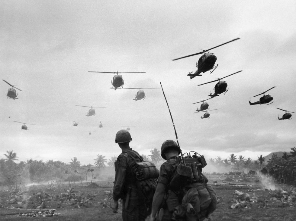 Huey helicopters in battle formation photographed from the ground during the Vietnam War