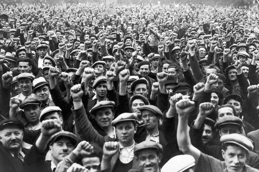 A crowd of workers with their fists in the air
