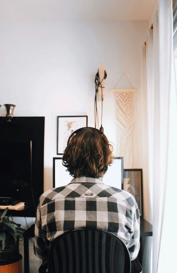 back view of a man sitting at a computer