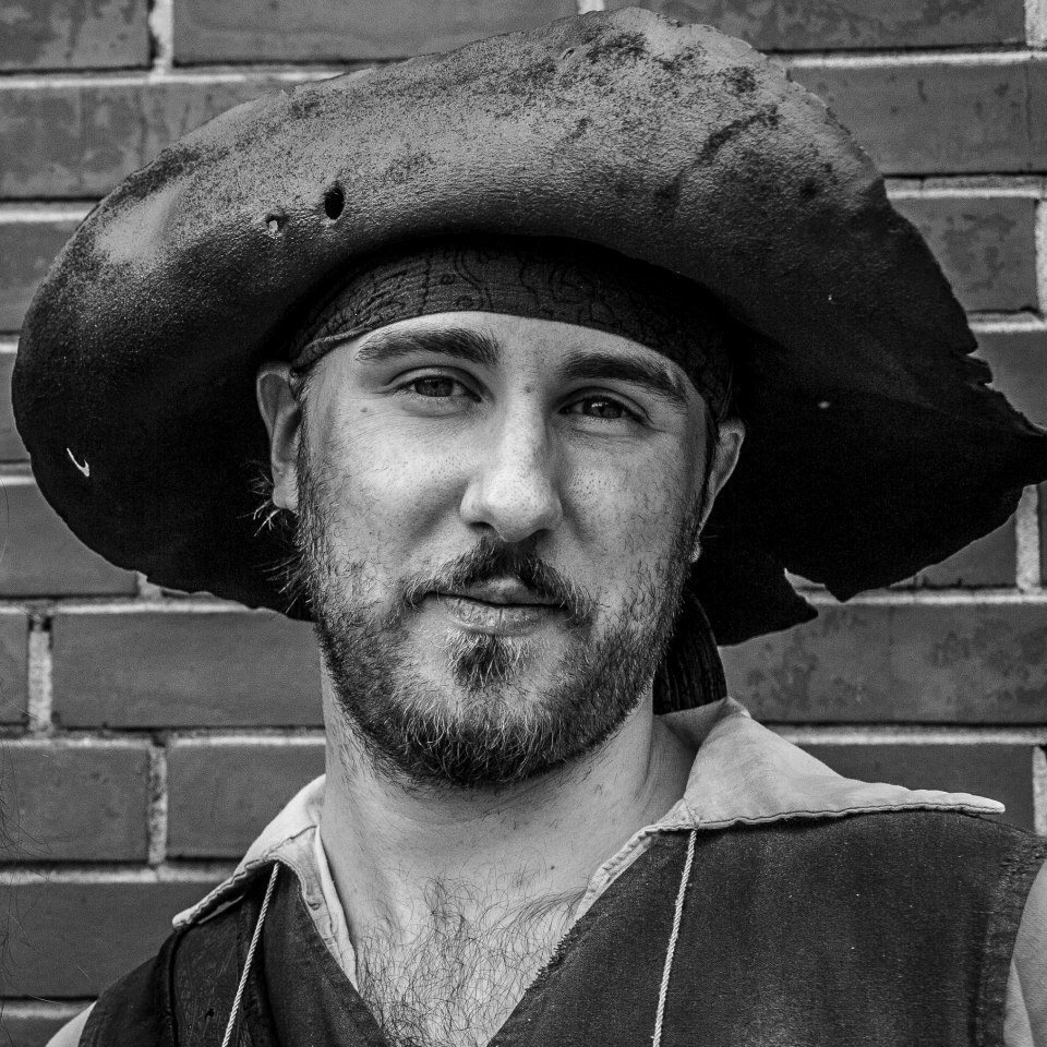 A young man dressed as a pirate, wearing a floppy felt hat
