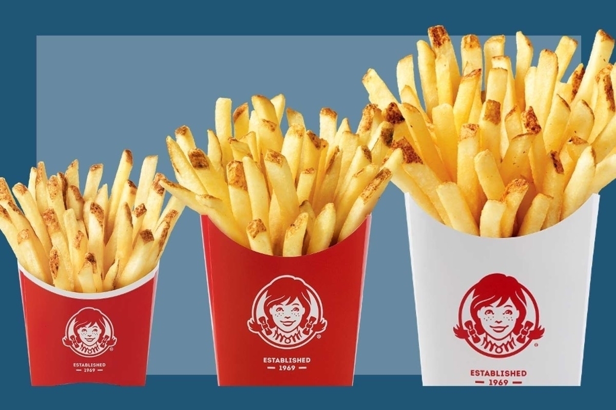 Three orders of french fries from Wendy’s in progressively larger containers.