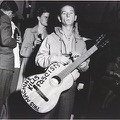 Woodie Guthrie holding a guitar
